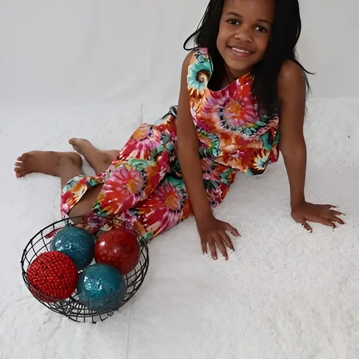 Girl in colorful dress with decorative balls.