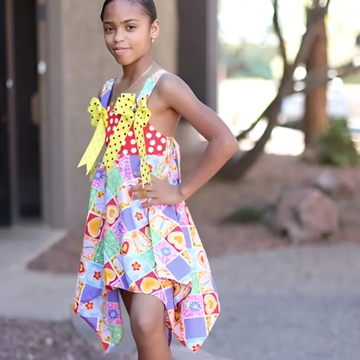 Girl in colorful dress posing outdoors.