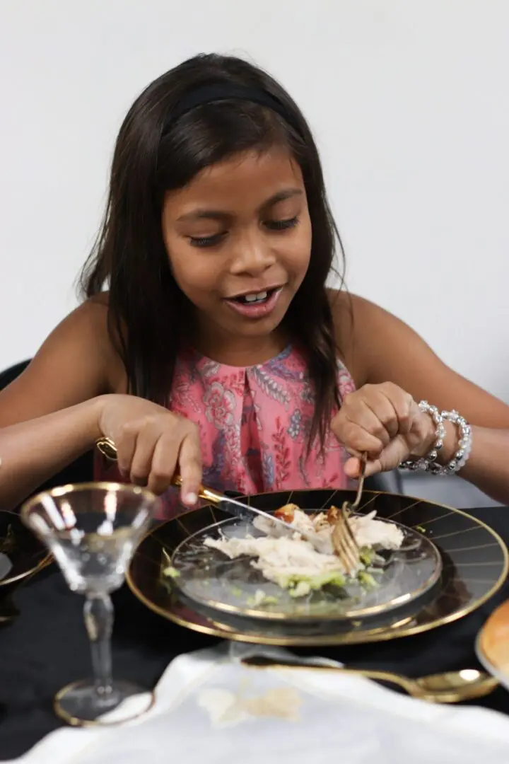Girl enjoying a meal at a table.
