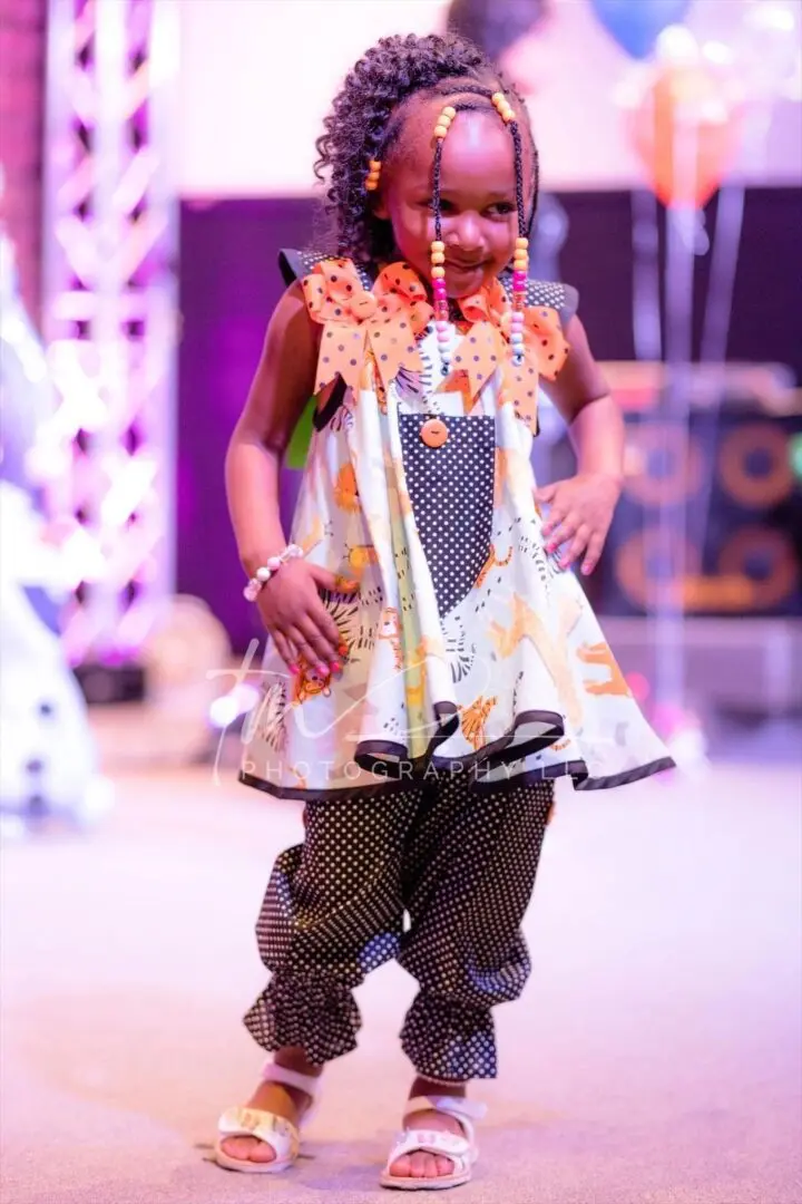 Young girl in colorful, festive outfit smiling.