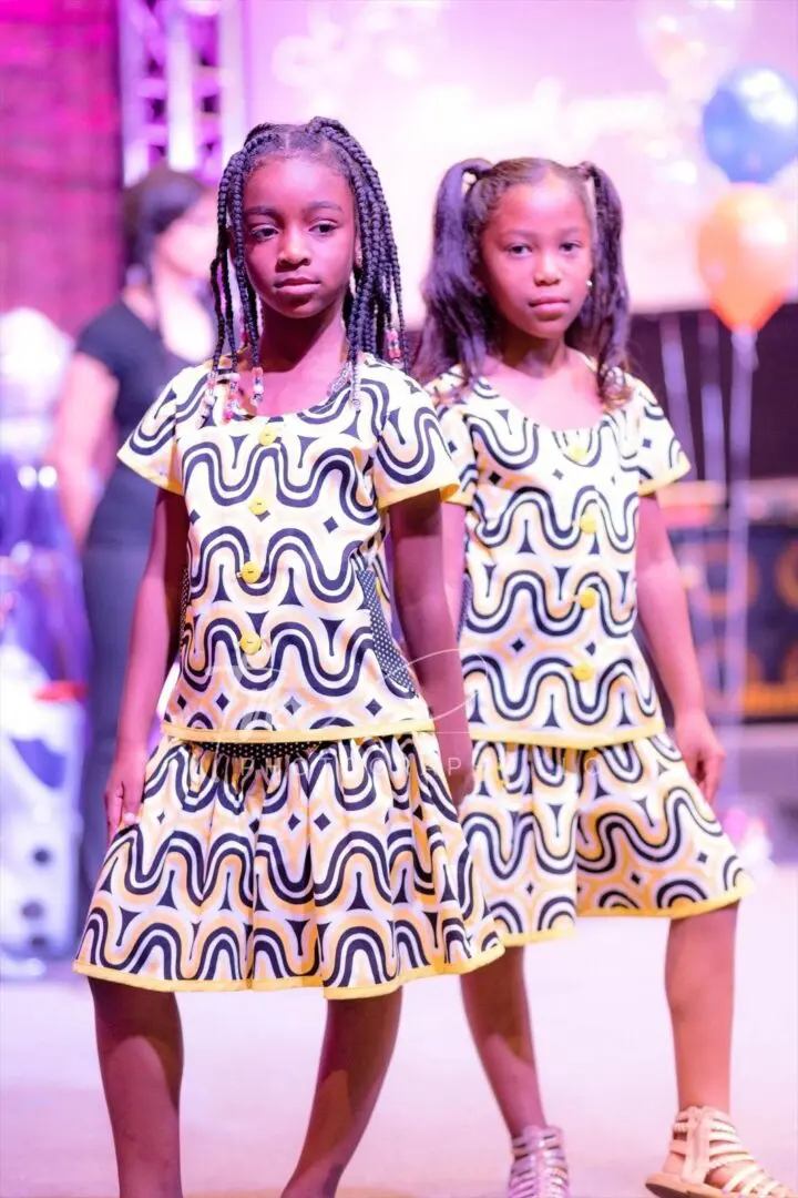 Two girls in matching patterned dresses.