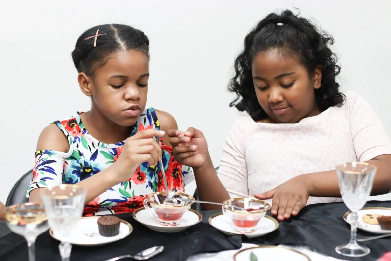 Two girls enjoying dessert at a table.