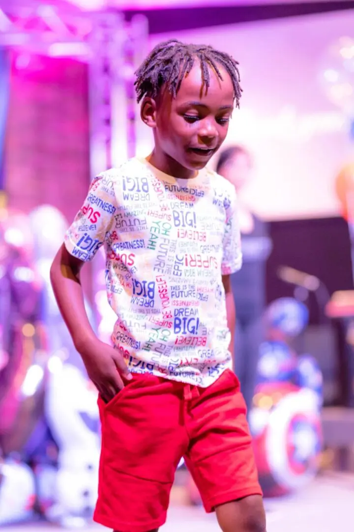 Child in colorful outfit on stage.