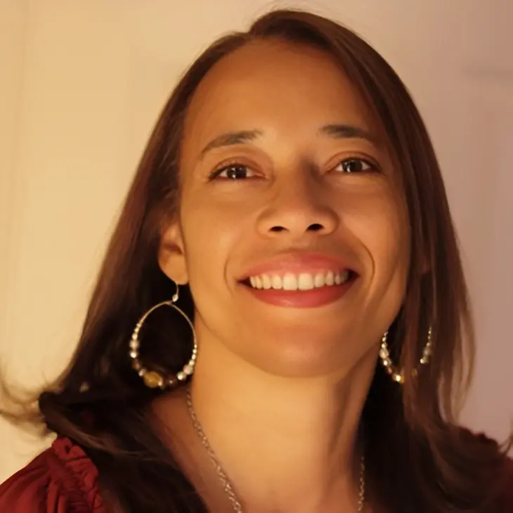 Smiling woman with long hair and earrings.