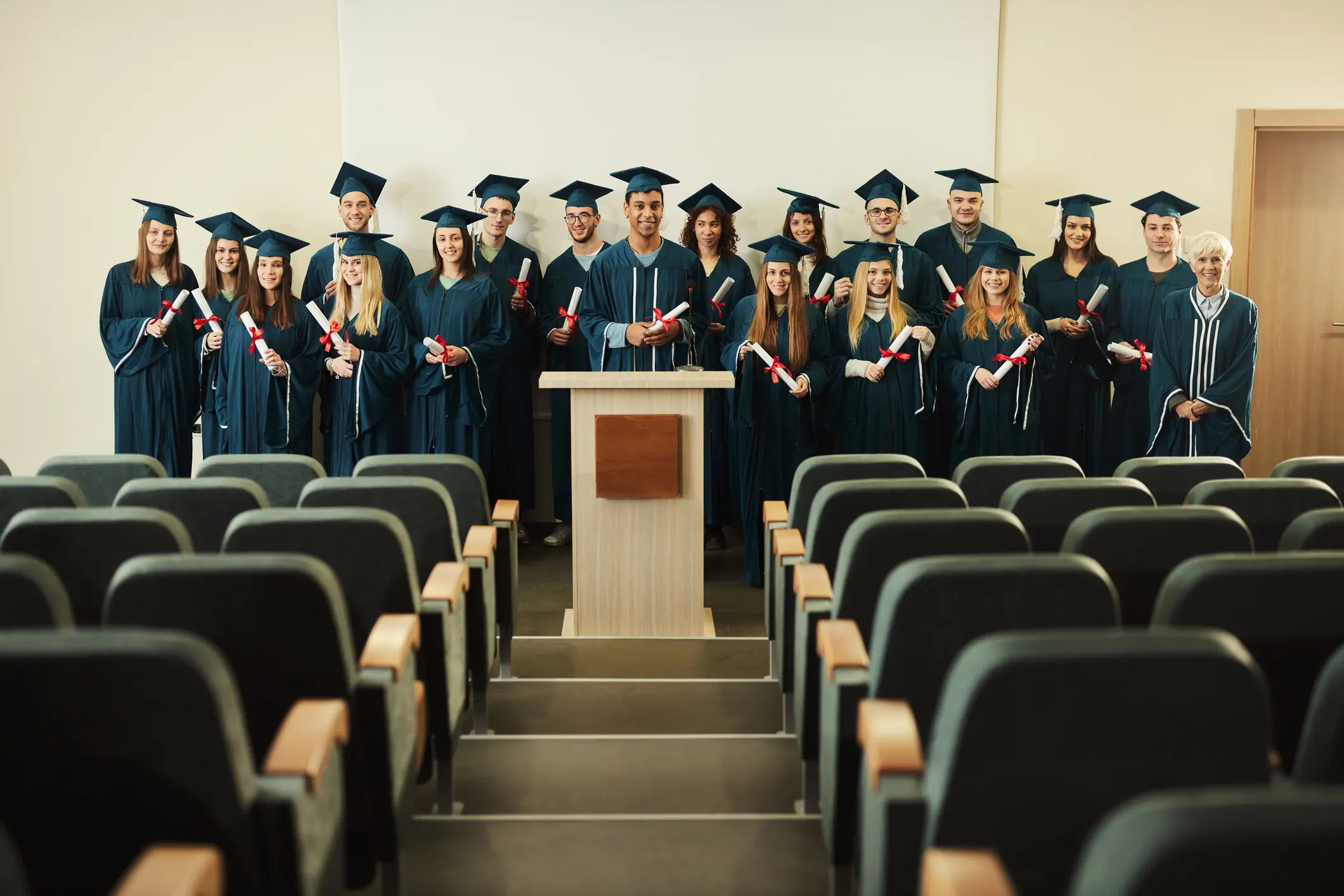 A group of graduates in caps and gowns standing on stage.