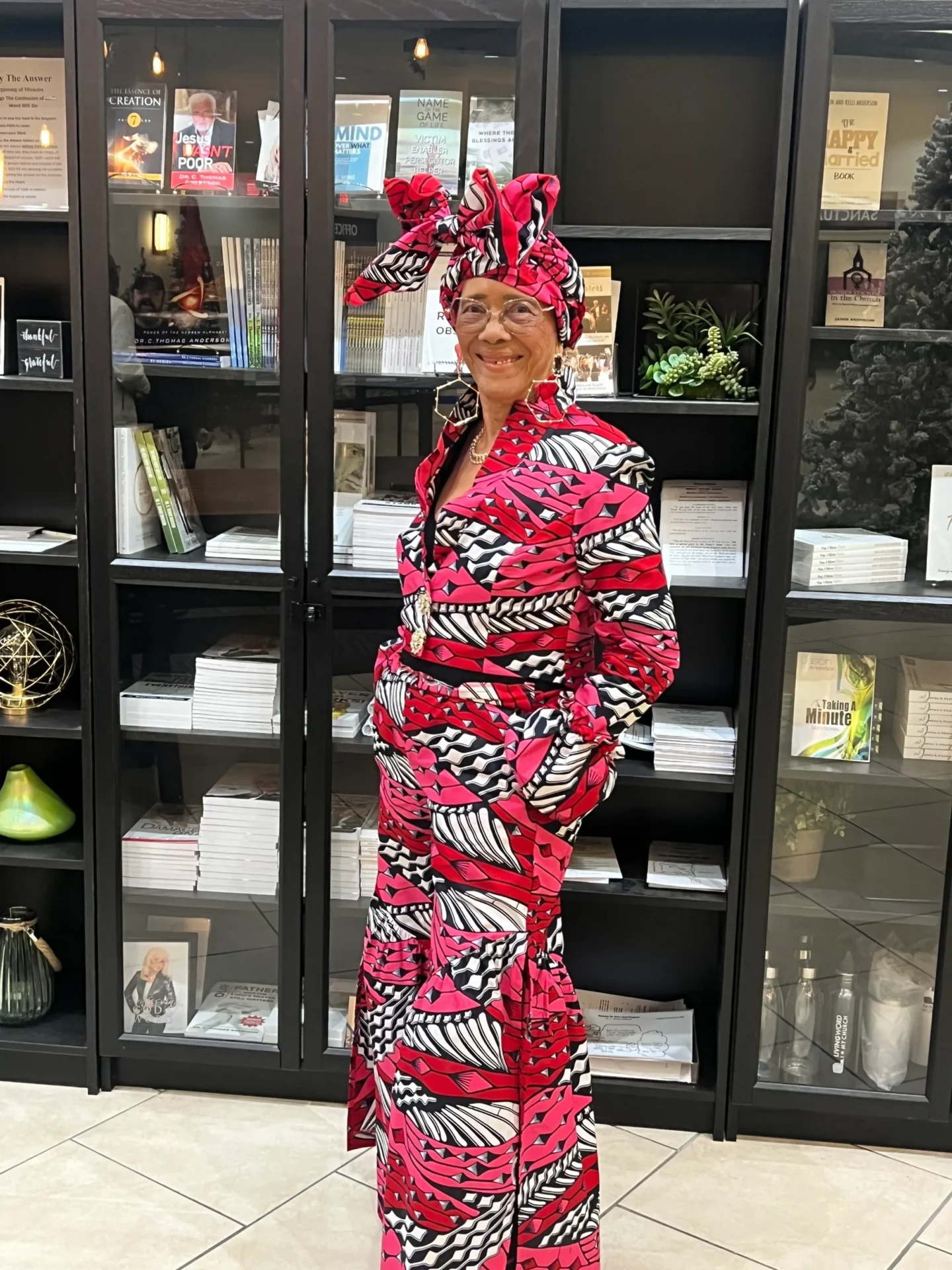 Person in vibrant patterned attire, smiling indoors.
